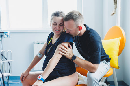 A husband hugs his wife who is giving birth. Giving birth together. Partnered birth. Supporting a...