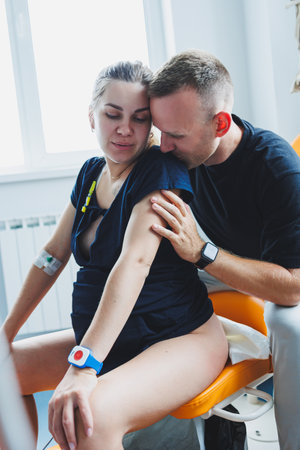 A husband hugs his wife who is giving birth. Giving birth together. Partnered birth. Supporting a...