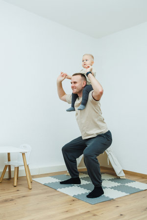 A father and his child joyfully bond over fitness activities at home, happily enjoying their precious time togetherの写真素材