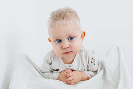 Smiling blond boy playing at home. Toddler boy playing at home and smiling at camera.