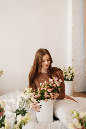 A woman is surrounded by colorful flowers, evoking feelings of tranquility and joy in a serene sceneの写真素材