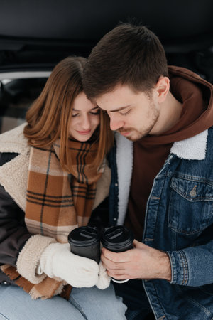 A lovely couple shares an intimate moment over steaming coffee during winter, enjoying each others companyの写真素材