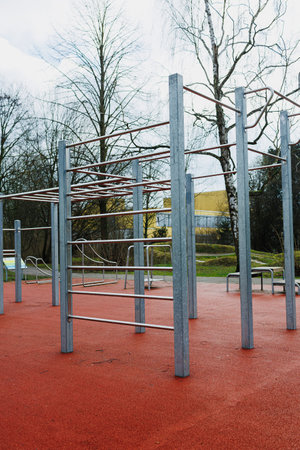There is a vibrant playground featuring numerous bars and structures, surrounded by a lush backdrop of trees adding a natural feel to the areaの写真素材