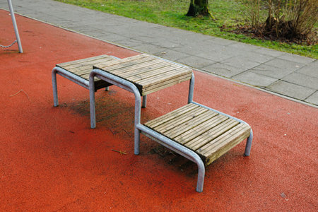 There is a wellcrafted set of wooden steps positioned on a vibrant red rubber surface, creating a striking contrast that catches the eyeの写真素材