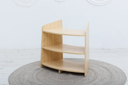 In a cozy room, a beautiful wooden shelf is gracefully situated on a charming round rug, adding to the aesthetic appeal of the spaceの写真素材