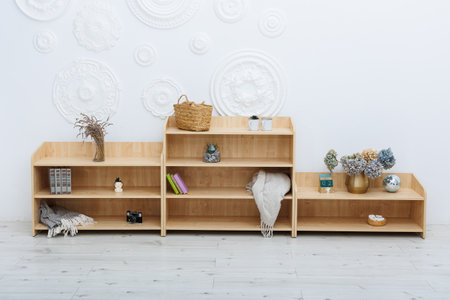 A long, neatly arranged row of wooden shelves filled with a variety of items placed carefully on them, creating an organized displayの写真素材