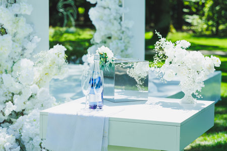 A beautifully arranged table that is elegantly decorated with delicate white flowers and features a refreshing bottle of water placed on itの写真素材