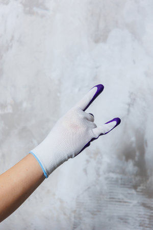 An elegantly adorned hand, fitted with a pristine white glove that features striking purple fingers, is enthusiastically making the iconic rock signの写真素材