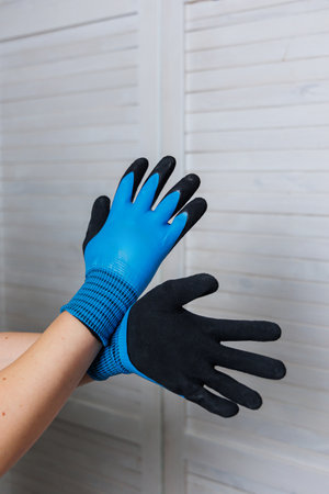 A person is wearing a stylish pair of blue and black gloves that are both fashionable and...