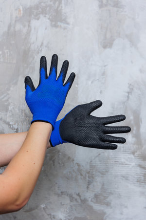 A person is wearing a distinctive pair of blue and black gloves, which are designed for various...