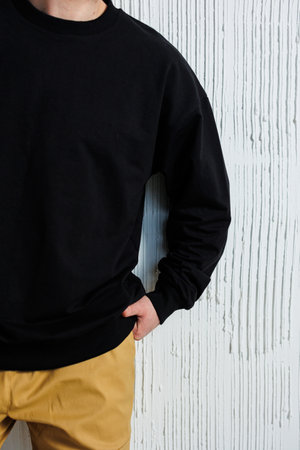 A trendy and stylish black sweatshirt beautifully paired with stylish khaki pants, perfect for casual outfitsの写真素材