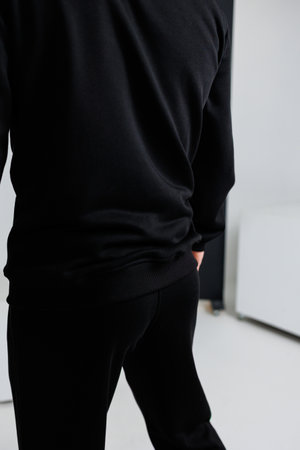 The back view of an individual wearing a stylish black shirt and sleek black pants, creating a fashionable monochrome lookの写真素材