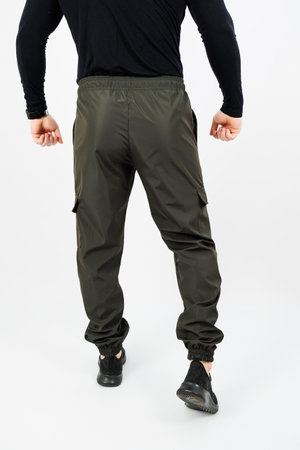 The rear view of a man who is dressed in a black shirt and green cargo pants, showcasing his style and choice of clothing, carries a confident demeanorの写真素材
