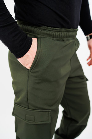 A man is dressed in a black shirt paired with green pants while casually placing his hand into his pocketの写真素材