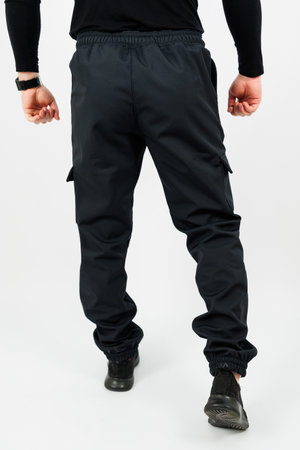 The back view of a man who is dressed in stylish black cargo pants, showcasing their practical pockets and trendy designの写真素材