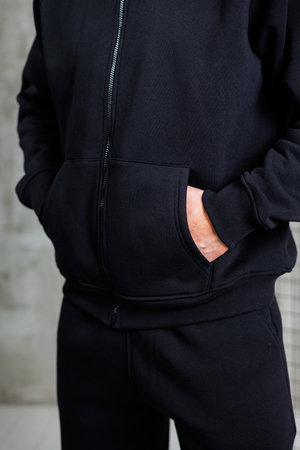 A stylish person in a black hoodie and matching pants, perfect for casual outings or intense workoutsの写真素材