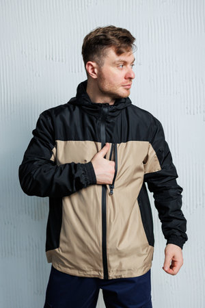 A person donning a stylish black and tan jacket complete with a functional zipper, showcasing both fashion and practicality in their attireの写真素材