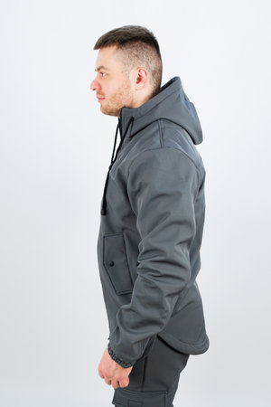 A man is wearing a stylish grey jacket that has a comfortable hood attached to it, which adds both warmth and a casual lookの写真素材