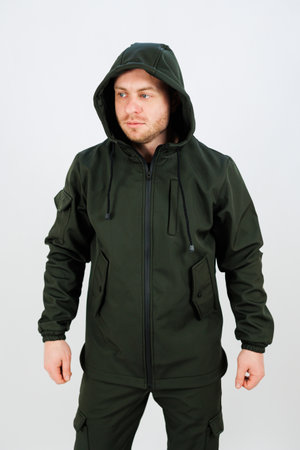 A man is wearing a vibrant green jacket that features a cozy hood, perfect for keeping warm during chilly weatherの写真素材