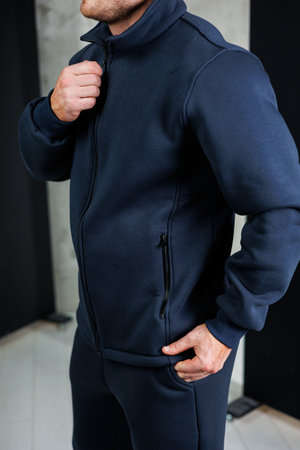 A man dressed in a stylish blue jacket has his hand comfortably tucked away inside his jacket pocket, showcasing a casual yet fashionable lookの写真素材