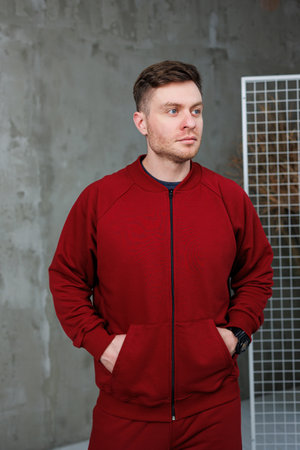 A man wearing a bright red jacket with both of his hands comfortably tucked into the pockets of his jacket, exuding a relaxed vibeの写真素材
