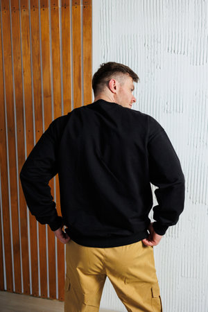The back view of a man who is dressed in a black sweatshirt along with a pair of vibrant yellow pants, creating a striking contrast,の写真素材