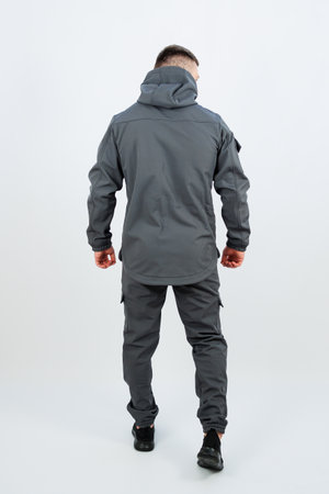 A man is seen from the back, dressed in a stylish grey jacket that features a hood, perfect for an outdoor winter adventureの写真素材