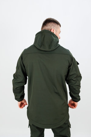 The back view of a man who is wearing a green jacket that features a hood, exemplifying a military camouflage style and practicalityの写真素材
