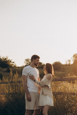 A loving couple embraces, lost in joy and deep love, surrounded by a stunning sunset that reflects their bond and the tranquility of nature in this beautiful settingの写真素材