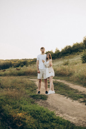 In a sunny, vibrant field, a loving couple tenderly embraces each other, capturing a beautifully intimate moment of affection amidst the lush greenery and serene beauty of natureの写真素材