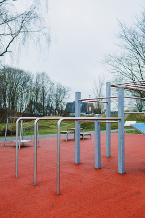 A scenic view showcasing steel playground equipment resting on a safe rubber surface in a peaceful outdoor settingの写真素材