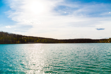 A peaceful and tranquil lake beautifully capturing the warm sunlight along with the lush greenery in natureの写真素材