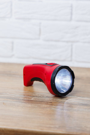 This is a vibrant red handheld flashlight, which is ideal for camping, power outages, or any emergency situationsの写真素材