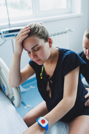 Pregnant woman feels severe pain during childbirth in hospital ward. Caring man helps woman during childbirth and massages her back. Support and love concept.の写真素材