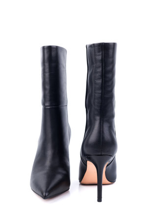 Black leather women's ankle boots with high heels on a white background. Women's stylish autumn shoes. Spring elegant women's boots with heelsの写真素材