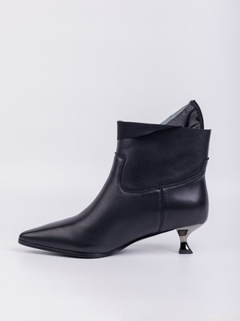 Elegant women's boots with heels made of genuine leather in black with fasteners on a white background. Stylish autumn women's shoes for every dayの写真素材