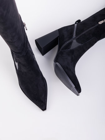 Women's high-heeled suede boots. Elegant black women's boots. Winter elegant women's shoesの写真素材