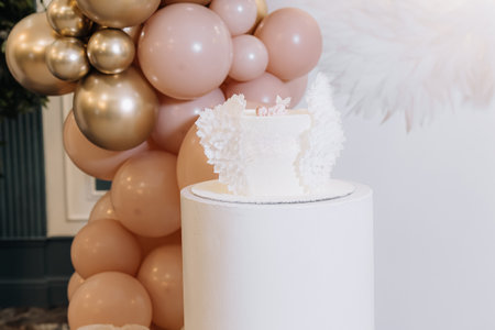 A stunning threetiered white wedding cake with intricate designs, paired with soft pastel balloons, creating a charming festive atmosphere for the special occasionの写真素材