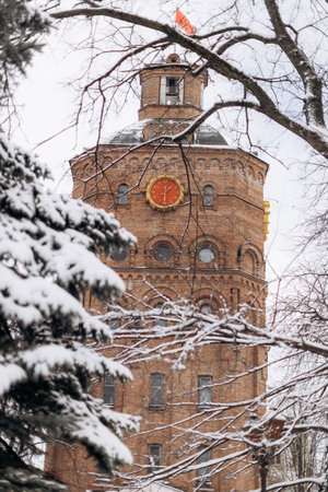A historic snowcovered tower with a vibrant clock stands among frosty trees, creating an enchanting winter wonderland that attracts many eager visitors each seasonの写真素材