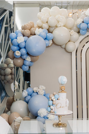 This stunning pastel balloon arrangement, paired beautifully with an elegant cake, serves as the perfect centerpiece for an unforgettable first birthday or any joyous celebrationの写真素材