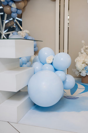 The vibrant blue balloons, along with the delicate white flowers and modern white geometric structures, create a warm and inviting atmosphere that is perfect for any type of eventの写真素材