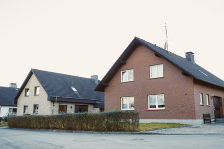 Admire this captivating image showcasing diverse residential houses with unique textures and designs, all set in a peaceful suburban environment that enhances their charmの写真素材