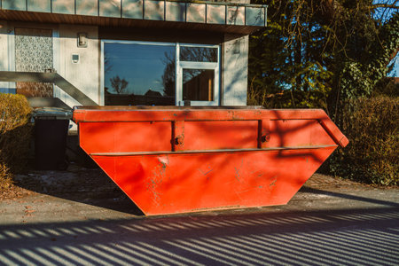 Large metal container for construction waste. Container stands near the house to remove waste after renovation. Removal of construction waste.の写真素材