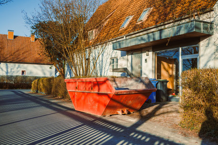 Large metal container for construction waste. Container stands near the house to remove waste after renovation. Removal of construction waste.の写真素材