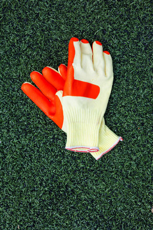 Durable protective gloves featuring a bright orange coating on the palm, perfect for a variety of work tasks like gardening and construction. Comfortable and reliable.の写真素材