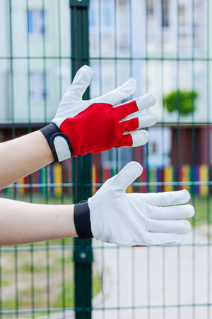 This image showcases a pair of work gloves, one red and the other white, highlighting their utility for outdoor workの写真素材