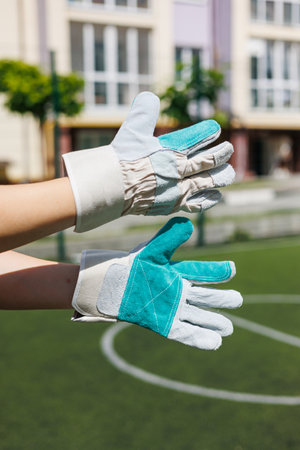 Presenting two unique pairs of gloves that are perfect for gardening and various outdoor work activities, all set against the backdrop of a vibrant and lush fieldの写真素材