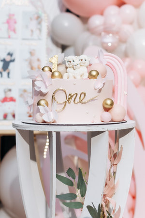 This charming pink cake for a first birthday features teddy bears, gold accents, and flowers, bringing joy and grace, ideal for creating unforgettable memoriesの写真素材