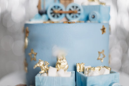 This whimsical blue train cake, beautifully adorned with shiny gold stars and adorable mini gifts, is truly perfect for celebrating a childs birthday or any festive occasionの写真素材
