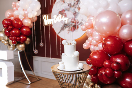 A beautifully designed birthday celebration with a decorated cake, colorful balloons, and an elegant backdrop for a memorable and joyous occasion everyone will cherishの写真素材